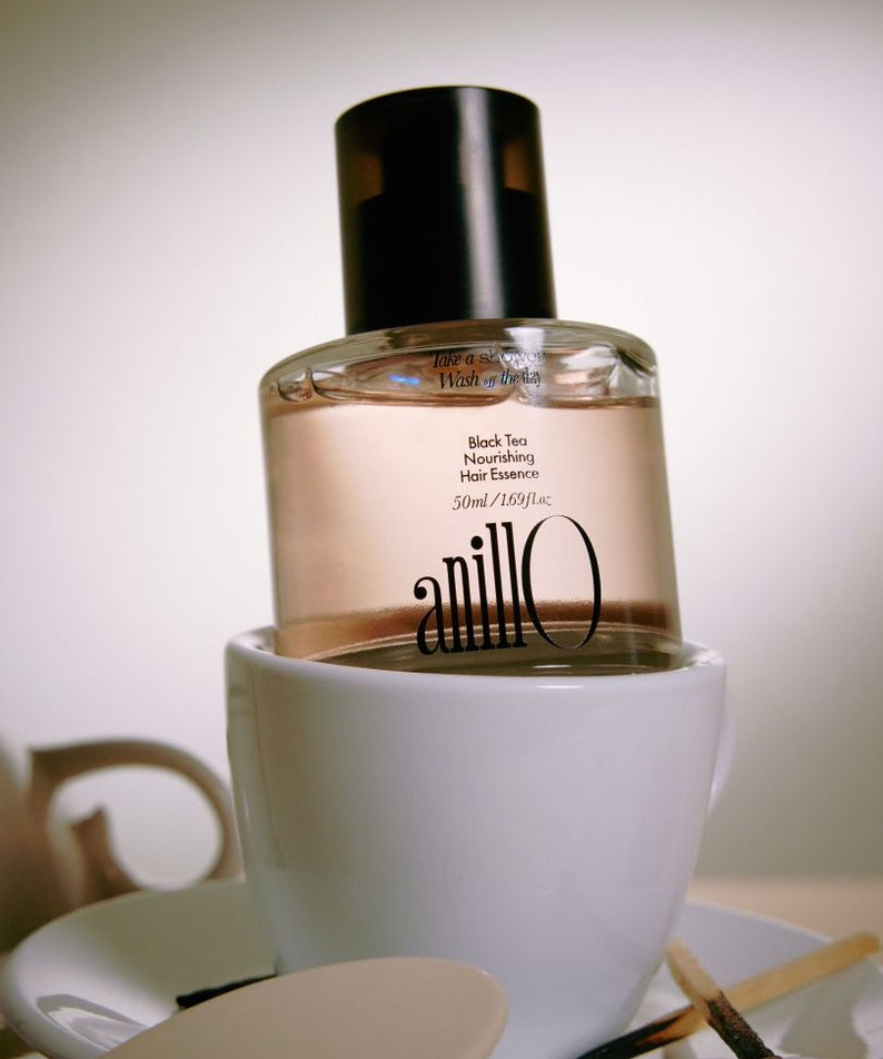 ANILLO Black Tea Nourishing Hair Essence 50ml, flacon en verre noir sur fond salle de bain, marque ANILLO