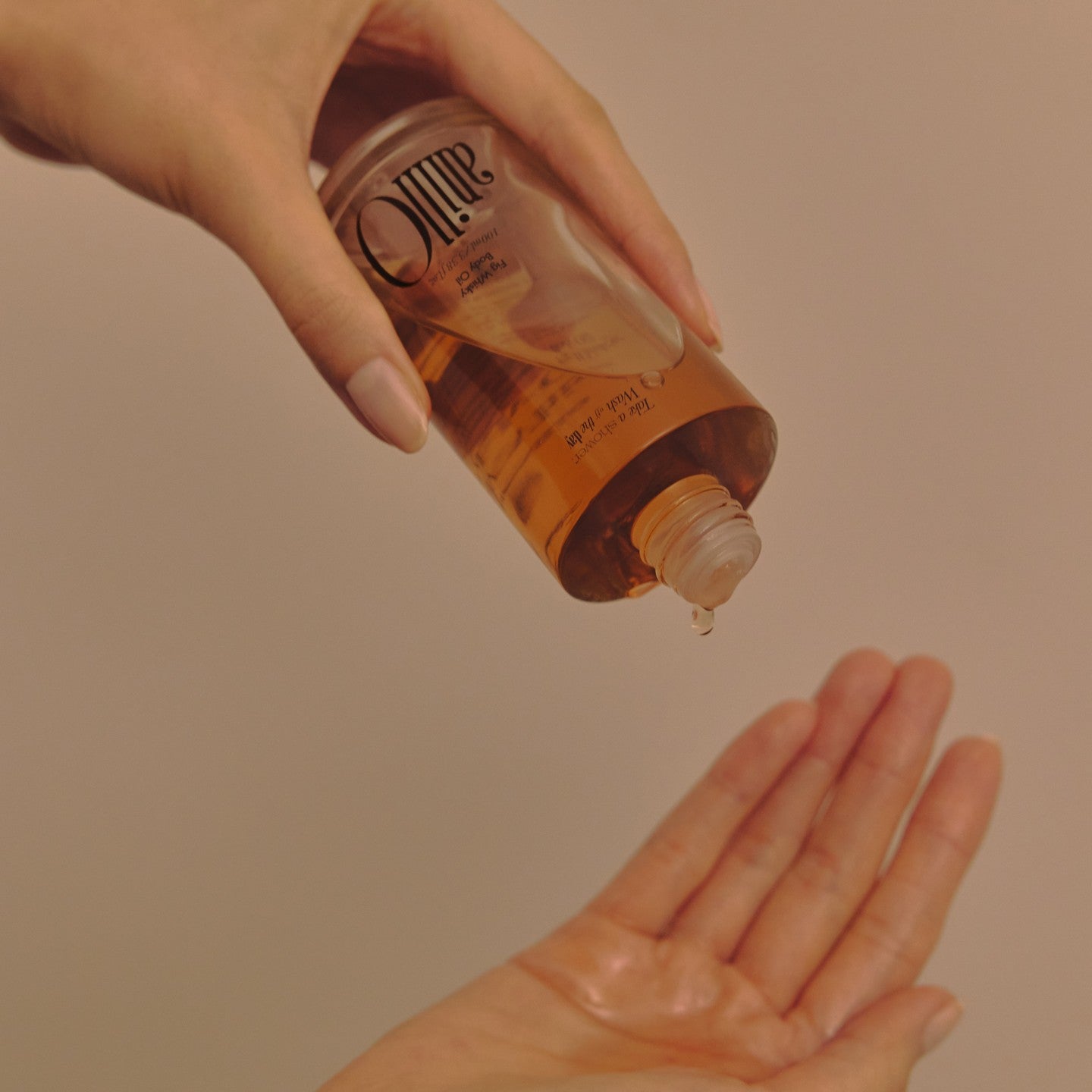 ANILLO Fig Whisky Body Oil 100ml, main applique sur peau, visuel cosmétique chaleureux, marque ANILLO, figue whisky