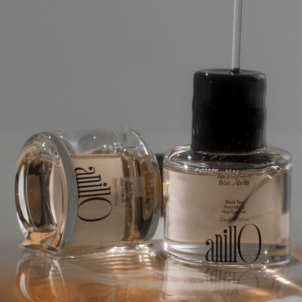 ANILLO Black Tea Nourishing Hair Essence 50ml : flacon noir et blanc sur fond clair, photo produit en studio.