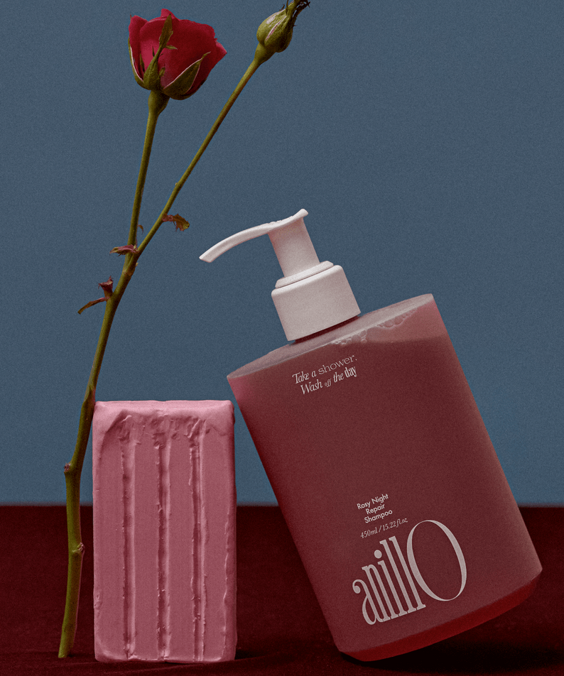ANILLO Rosy Night Repair Shampoo 450ml en flacon rose, présenté sur fond bleu avec bougie et fleurs, marque ANILLO