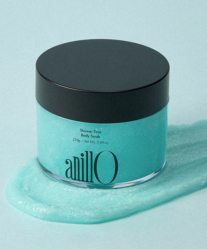 ANILLO Shower Time Body Scrub 210g : pot bleu noir sur gel douche, ambiance salle de bain, marque ANILLO en gros plan.