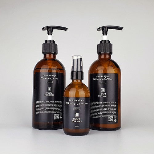 ANNA HOLTZ For Men Double Effect Whitening 3 Pieces Set : 3 flacons bruns avec pompes, arrière-plan clair, marque ANNA HOLTZ.