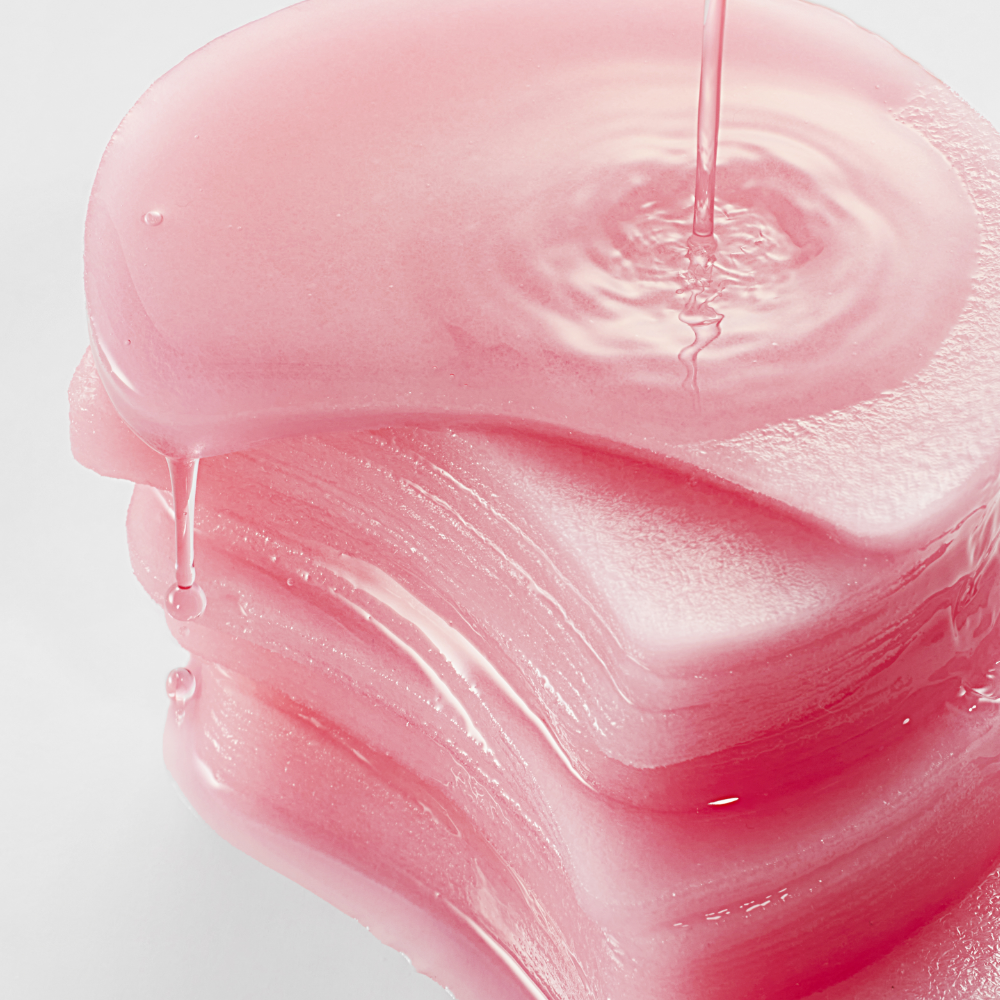 ANUA Niacinamide 5 TXA Brightening Pad 60 Pads de marque ANUA : visuel gros plan sur une texture sérum rose, en gouttes.