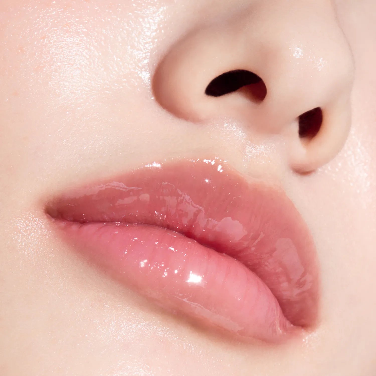 Gros plan sur les lèvres brillantes avec ANUA PDRN Lip Serum, marque ANUA, texture de sérum sur la peau.