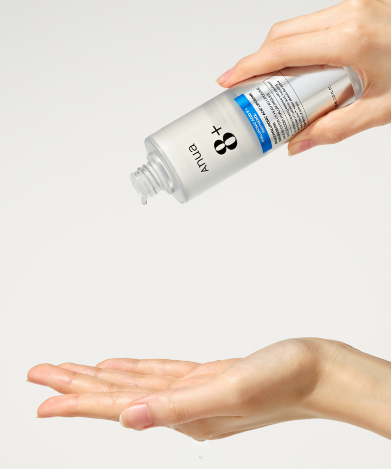 Main tenant ANUA Hyaluronic Acid 8 + Panthenol Lipsome Skin Booster 150ml, marque ANUA sur fond clair, démonstration soin