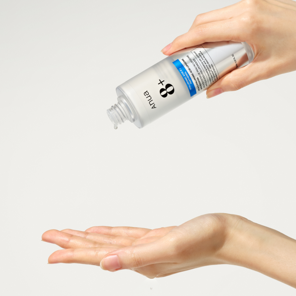 Main tenant ANUA Hyaluronic Acid 8 + Panthenol Lipsome Skin Booster 150ml, marque ANUA sur fond clair, démonstration soin