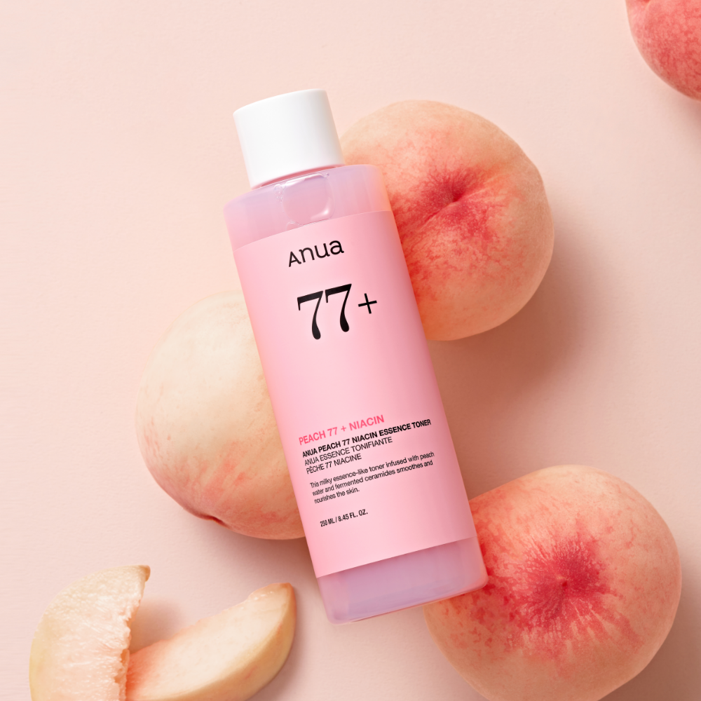 ANUA Peach 77 + Niacin Essence Toner 250ml d’ANUA en flacon rose sur fonds pastel, entouré de pêches.