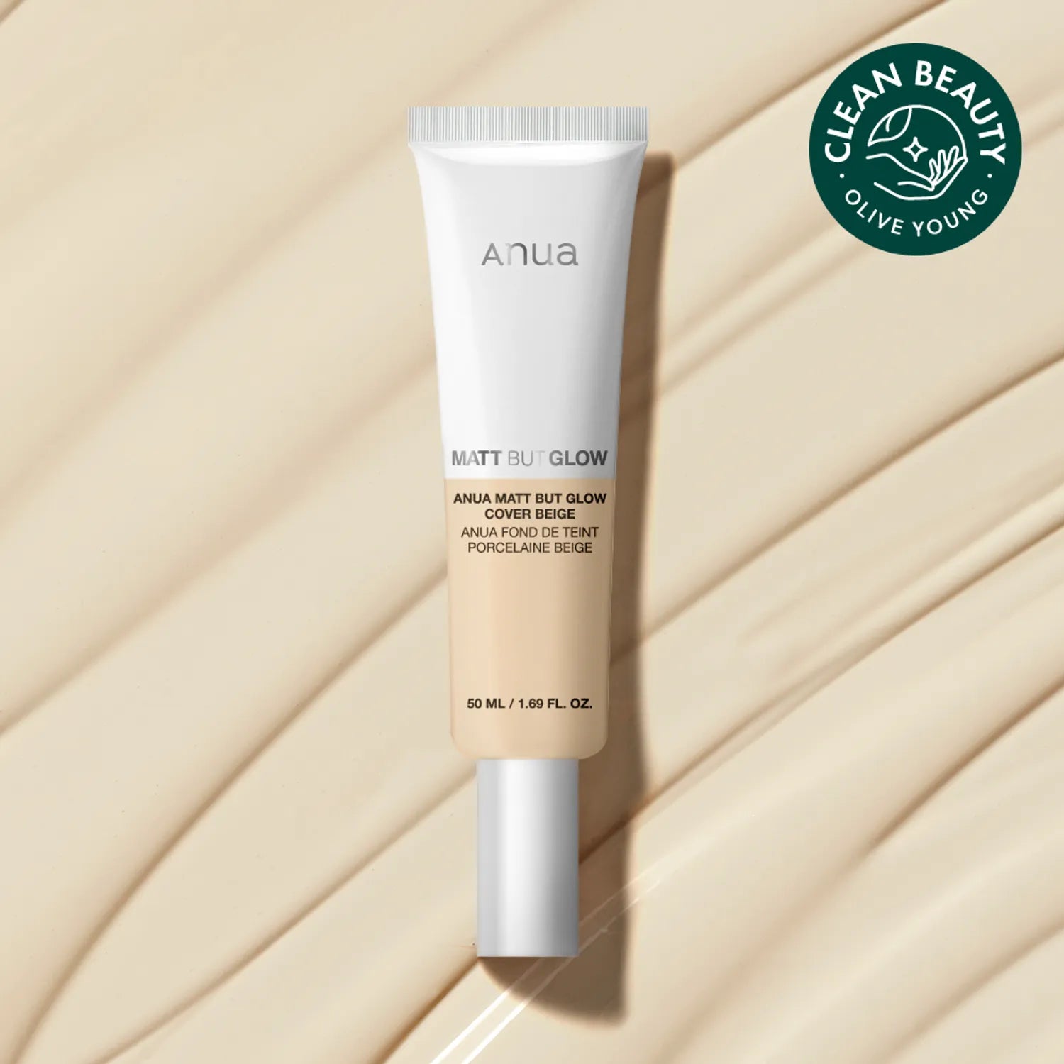 ANUA Matt But Glow Cover Beige 50ml, tube de maquillage sur tissu beige en studio, marque ANUA, lumière douce.