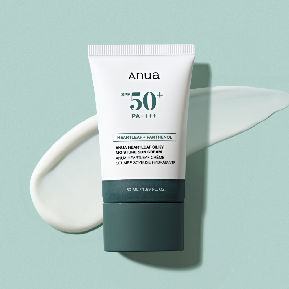 ANUA Heartleaf Silky Moisture Sun Cream 50ml, crème solaire Anua SPF50 sur fond vert, texture crème blanche en goutte.