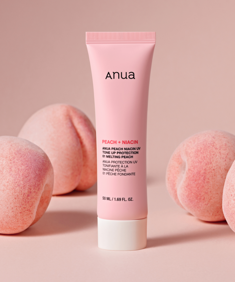 Décris l'image en français: ANUA Peach + Niacin UV Tone Up Protection 50ml, tube de marque Anua sur fond rose avec pêches