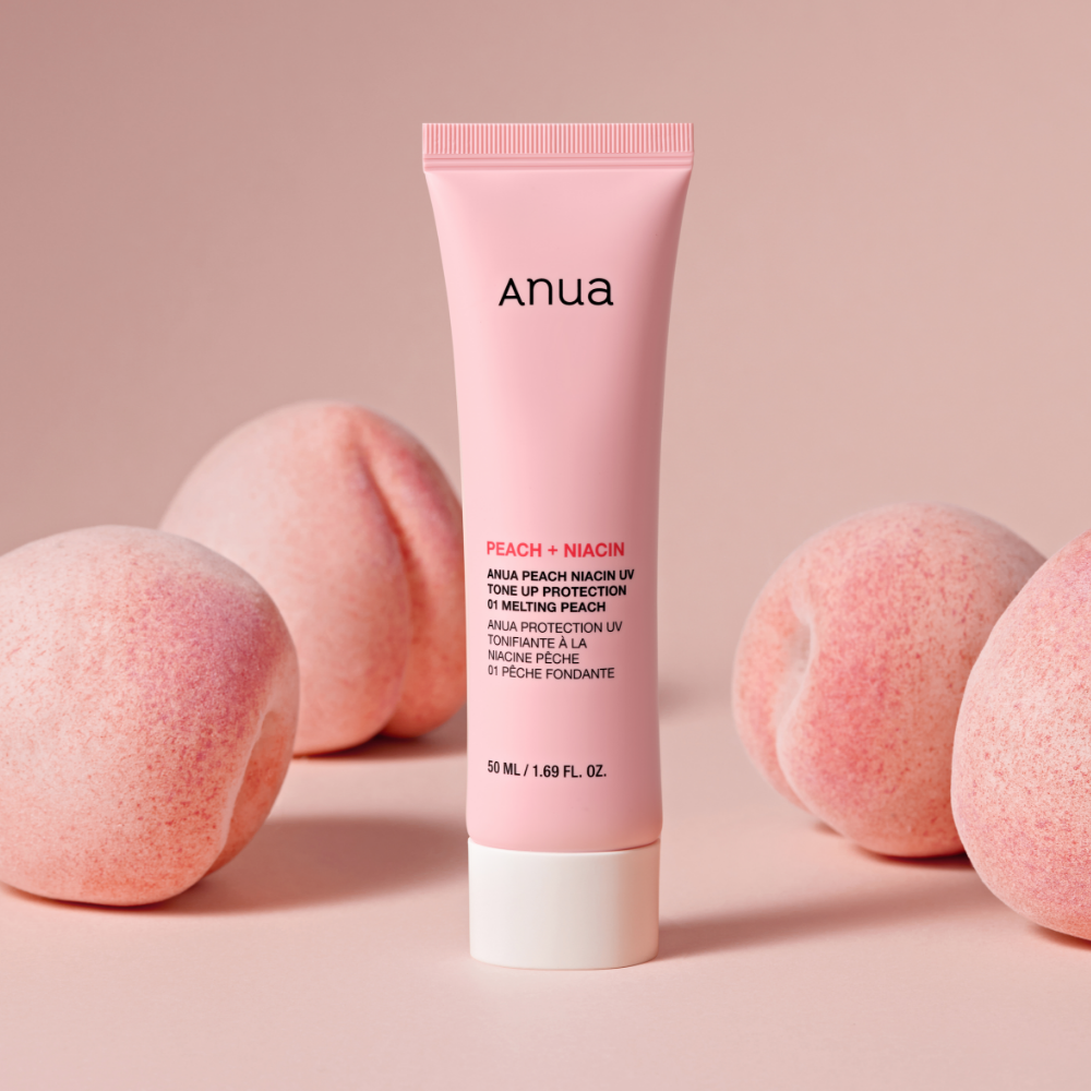 Décris l'image en français: ANUA Peach + Niacin UV Tone Up Protection 50ml, tube de marque Anua sur fond rose avec pêches