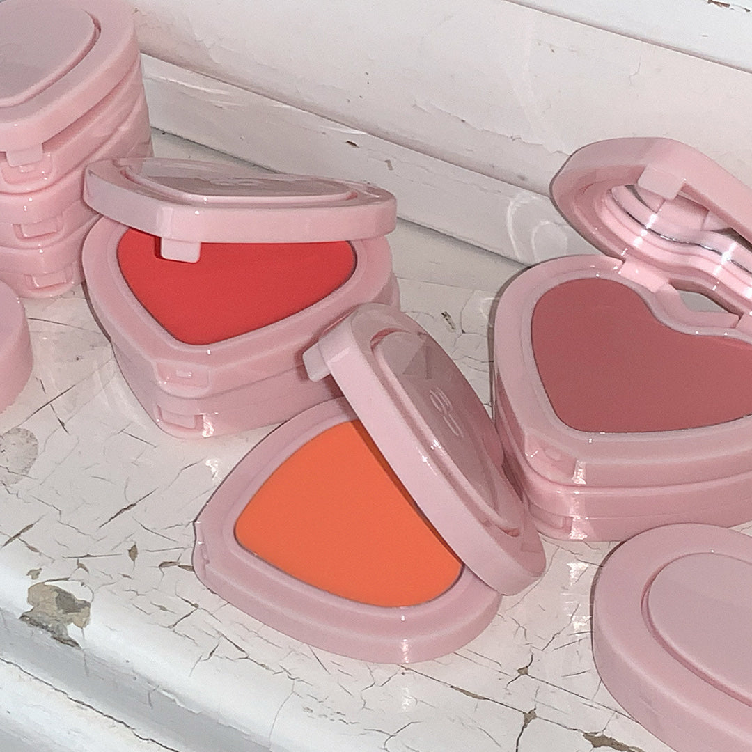 AOU Soft Cream Blush, corail et rose, packaging rose sur fond marbre clair, maquillage en gros plan, marque AOU