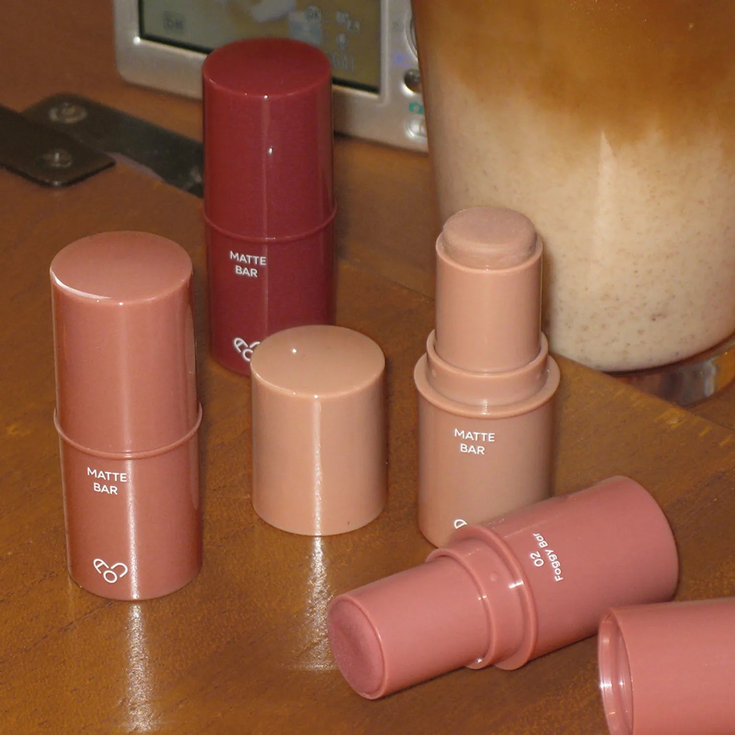 AOU Matte Bar de la marque AOU, sticks maquillage mats sur comptoir beige, ambiance salle de bain.