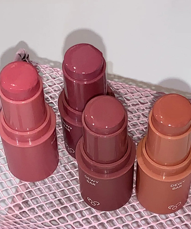 AOU Dewy Bar de la marque AOU, sur filet textile, 4 baumes dégradés rouges et roses en gros plan.