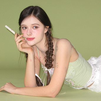 AOU Pinpoint Eyebrow Balm de la marque AOU, portrait maquillage sourcil sur fond vert, tube produit en main