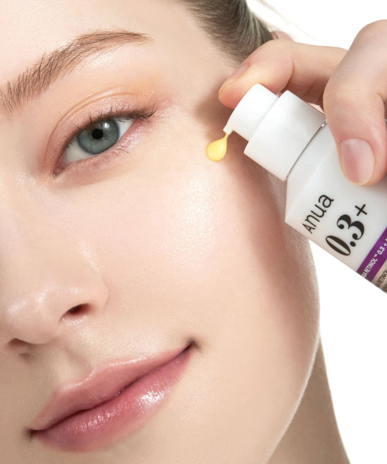 Visage en gros plan avec une pipette appliquant ANUA Retinol 0.3 Niacin Renewing Serum, marque ANUA, peau hydratée