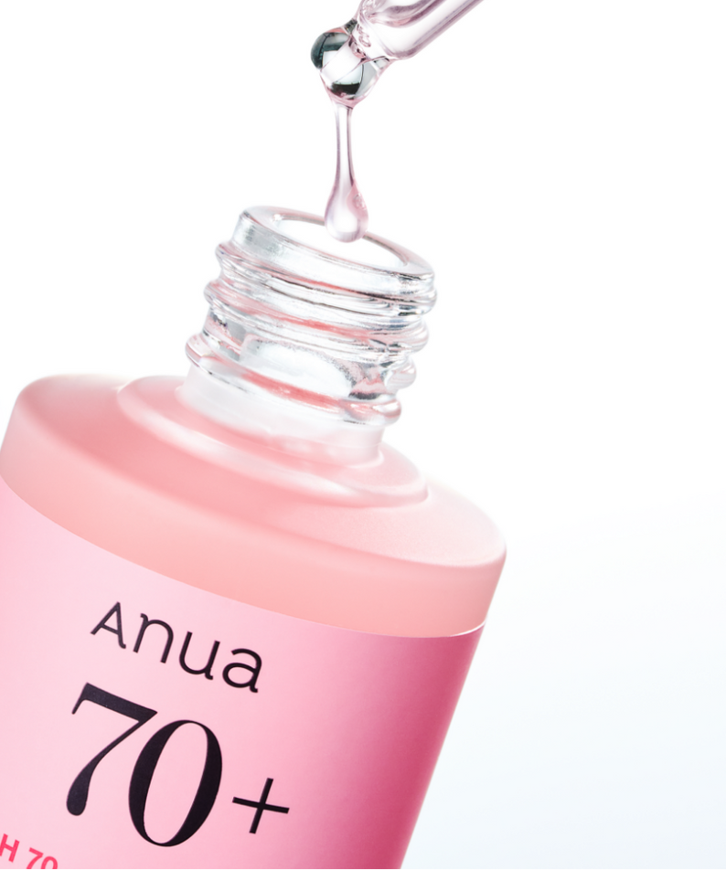 ANUA Peach 70 + Niacin Serum 30ml d’Anua, flacon rose avec sérum coulant, arrière-plan blanc, gouttes brillantes.