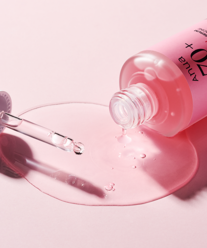 ANUA Peach 70 + Niacin Serum 30ml de la marque ANUA, sur fond rose, sérum coulant depuis le flacon.