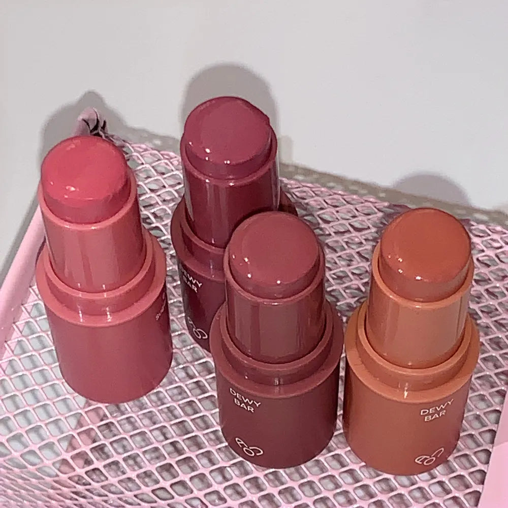 AOU Dewy Bar de la marque AOU, sur filet textile, 4 baumes dégradés rouges et roses en gros plan.