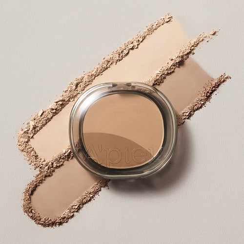 A'PIEU Juicy Pang Layering Shading, poudre contouring beige en pot sur fond nude, ombres et textures.