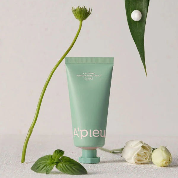 A'PIEU Juicy Pang Perfume Hand Cream 30ml, tube vert sur fond clair avec feuilles et fleurs, style cosmétique.
