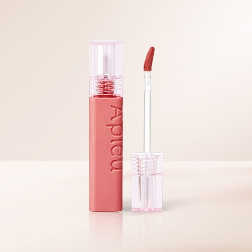 A'PIEU Juicy Pang Tint, baume teint rouge à lèvres de la marque A'PIEU, en pack rose avec applicateur sur fond clair.