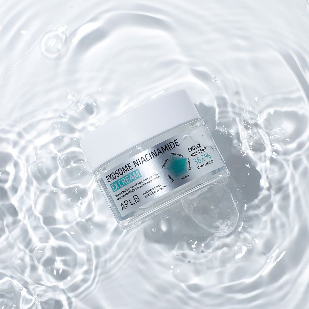 Décrivez l'image : APLB Exosome Niacinamide EX Cream 55ml, crème de marque APLB, posée sur des bulles d'eau.