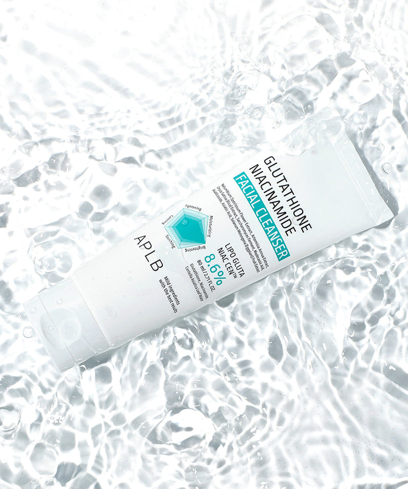 Décris l'image en français : APLB Glutathione Niacinamide Facial Cleanser 80ml sur tissu bulles, marque APLB, flacon blanc.