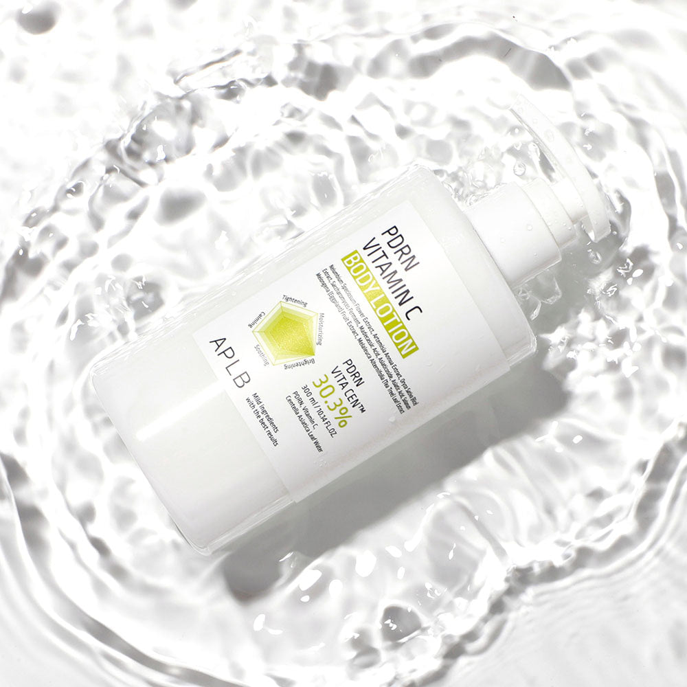 APL B PDRN Vitamin C Body Lotion 300ml de la marque APLB, flacon blanc sur fond crème froissé, lumière douce.