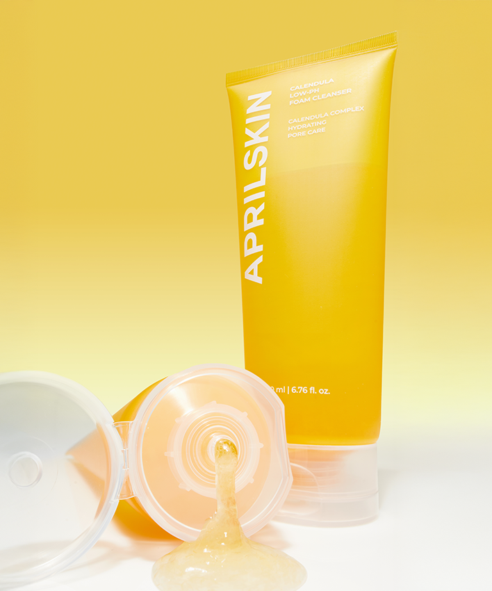 APRILSKIN Calendula Low PH Foam CLeanser présenté en tube jaune sur fond jaune, nettoyant visage doux et équilibrant pour la peau.