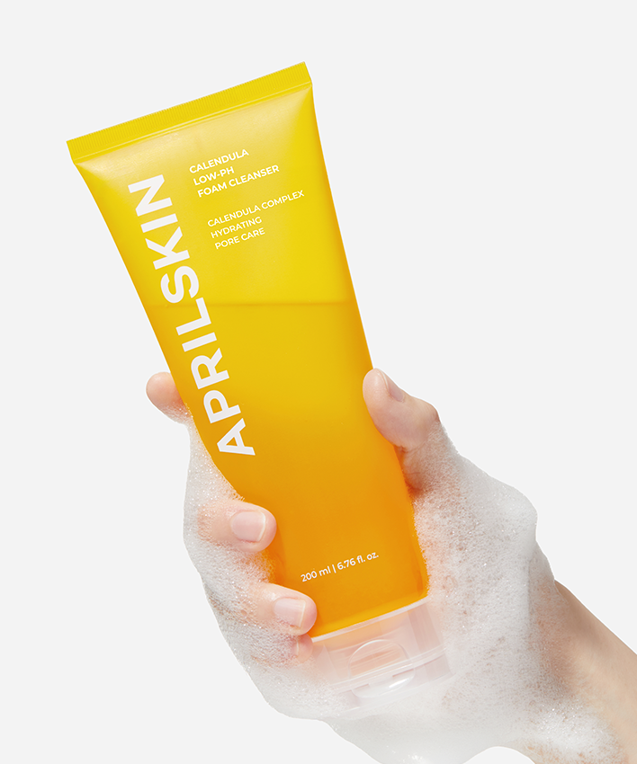Main tenant un tube de APRILSKIN Calendula Low PH Foam CLeanser, gel moussant doux pour peau sensible.