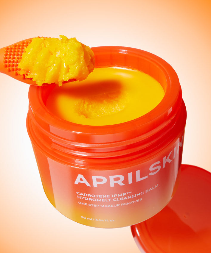 APRILSKIN Carotene Melting Cleansing Balm, baume démaquillant orange vif dans un pot ouvert, texture riche et crémeuse.