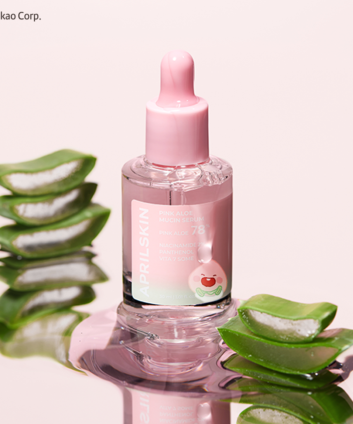 Flacon de APRILSKIN Pink Aloe Mucin Serum entouré de tranches d'aloès frais.