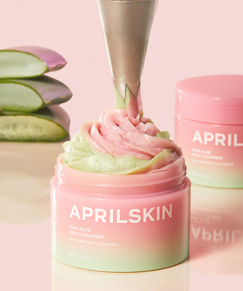 APRILSKIN Pink Aloe Pack Cleanser présenté avec une texture crème rose et verte, fond d'aloe vera coupé.