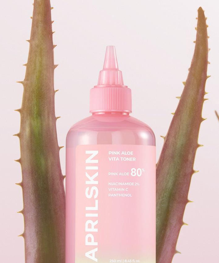 APRILSKIN Pink Aloe Vita Toner, flacon rose devant des feuilles d'aloe, produit de soin visage hydratant et apaisant.