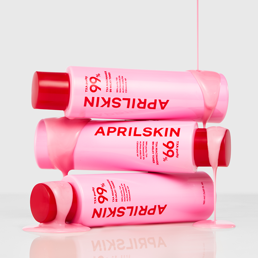 Décris l'image en français : APRILSKIN TXA Niacinamide 99 Milky Toner 150ml de la marque APRILSKIN, tubes roses sur fond clair.