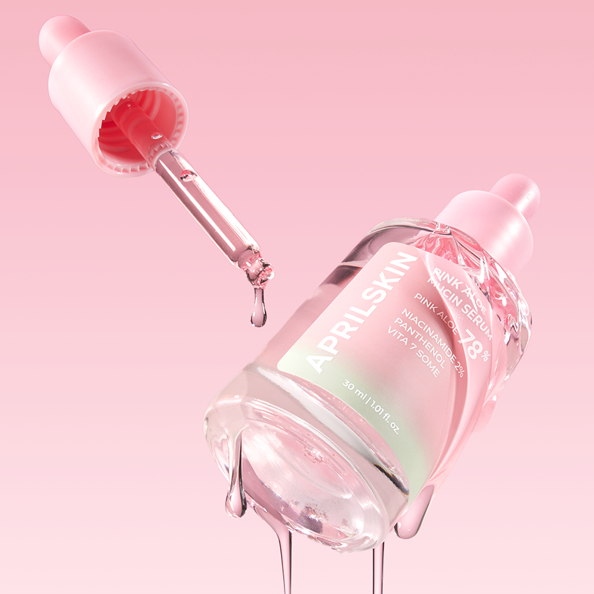APRILSKIN Pink Aloe Mucin Serum APRIL SKIN, bouteille rose et pipette gouttes sur fond rose pastel, contexte beauté