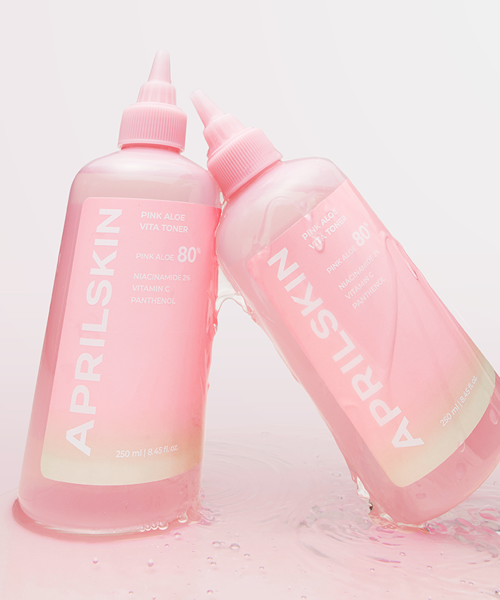 APRILSKIN Pink Aloe Vita Toner, bouteille rose de la marque APRILSKIN sur fond clair avec éclaboussures d’eau
