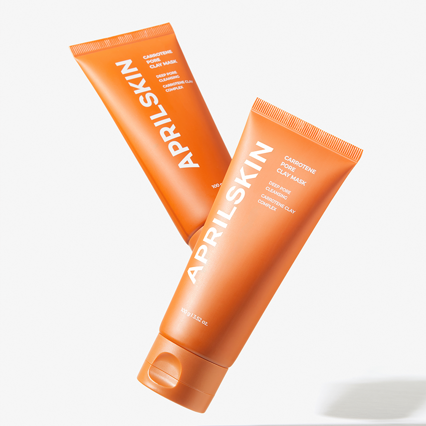 Décris l'image en français : APRILSKIN Carrotene Pore Clay Mask d'APRIL SKIN, masque à l'argile orange sur fond clair.