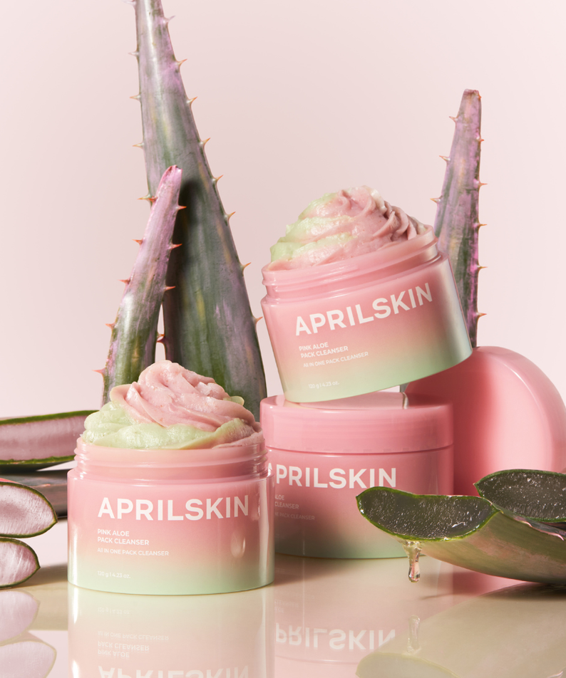APRILSKIN Pink Aloe Pack Cleanser de la marque APRILSKIN, packaging rose sur fond pastel avec aloe et plantes.