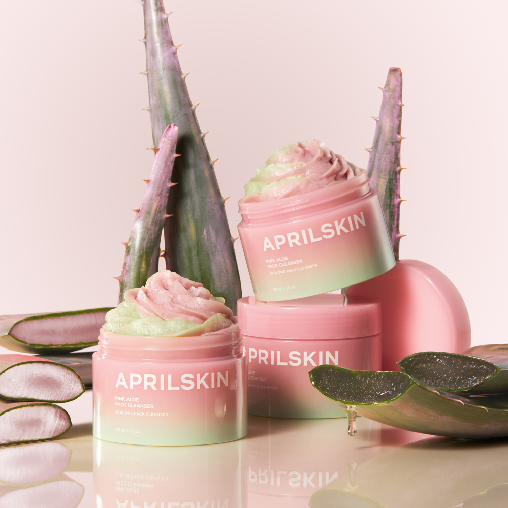 APRILSKIN Pink Aloe Pack Cleanser de la marque APRILSKIN, packaging rose sur fond pastel avec aloe et plantes.
