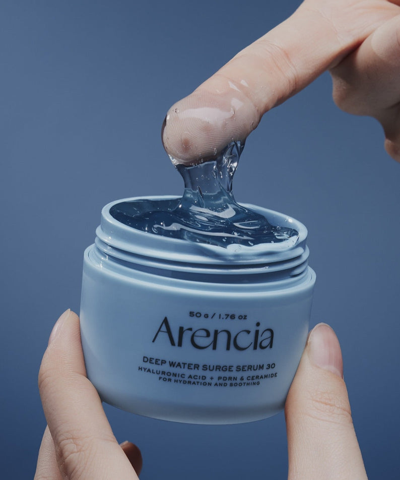 ARENCIA Deep Water Surge Serum 30 50g : pot ouvert, gel hydro, mains, fond bleu, marque Areancia en contexte soin visage