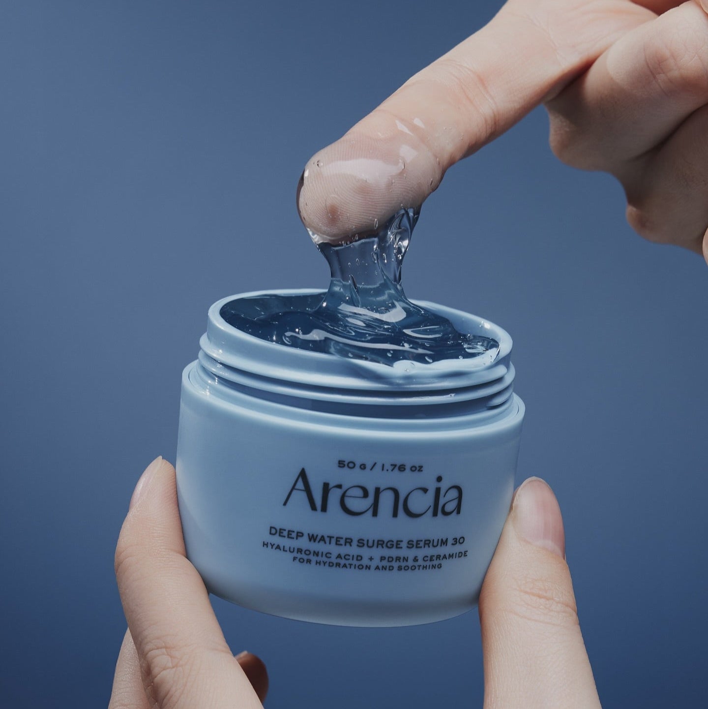 ARENCIA Deep Water Surge Serum 30 50g : pot ouvert, gel hydro, mains, fond bleu, marque Areancia en contexte soin visage