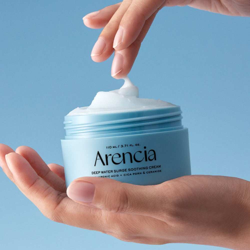ARENCIA Deep Water Surge Soothing Cream 80ml, pot de crème apaisante, mains appliquant la texture sur fond bleu.