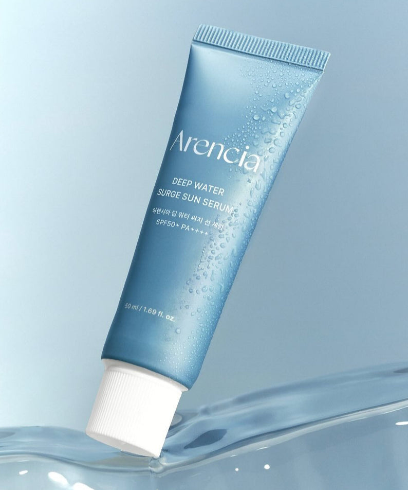 ARENCIA Deep Water Surge Sun Serum 50ml, tube bleu ARENCIA sur fond bleu, gouttes d’eau et ambiance solaire