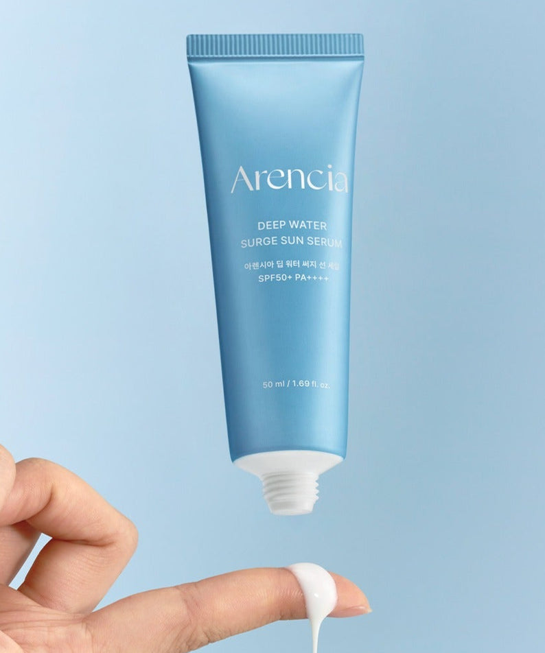 ARENCIA Deep Water Surge Sun Serum 50ml de la marque Arencia, flacon bleu sur fond clair, main applique une crème