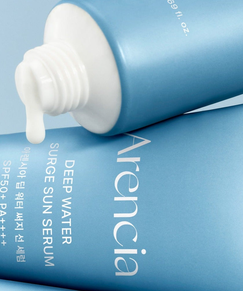 ARENCIA Deep Water Surge Sun Serum 50ml, flacon bleu et pompe, crème solaire hydratante sur fond bleu, produit en gros plan