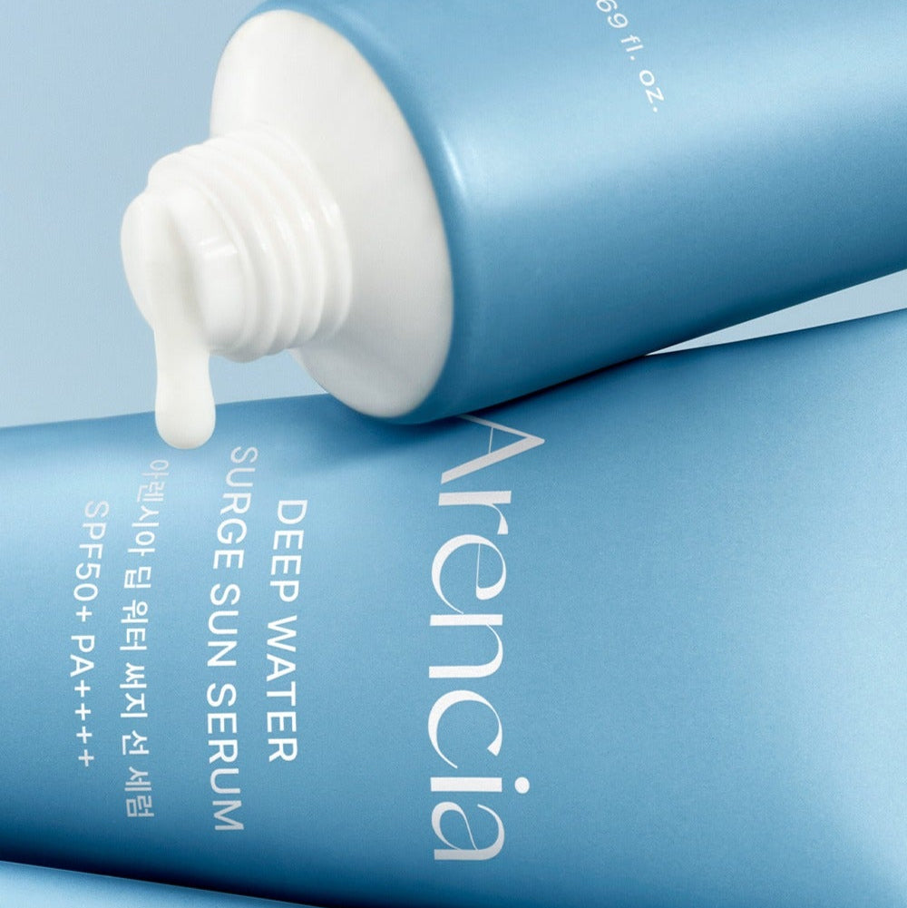 ARENCIA Deep Water Surge Sun Serum 50ml, flacon bleu et pompe, crème solaire hydratante sur fond bleu, produit en gros plan