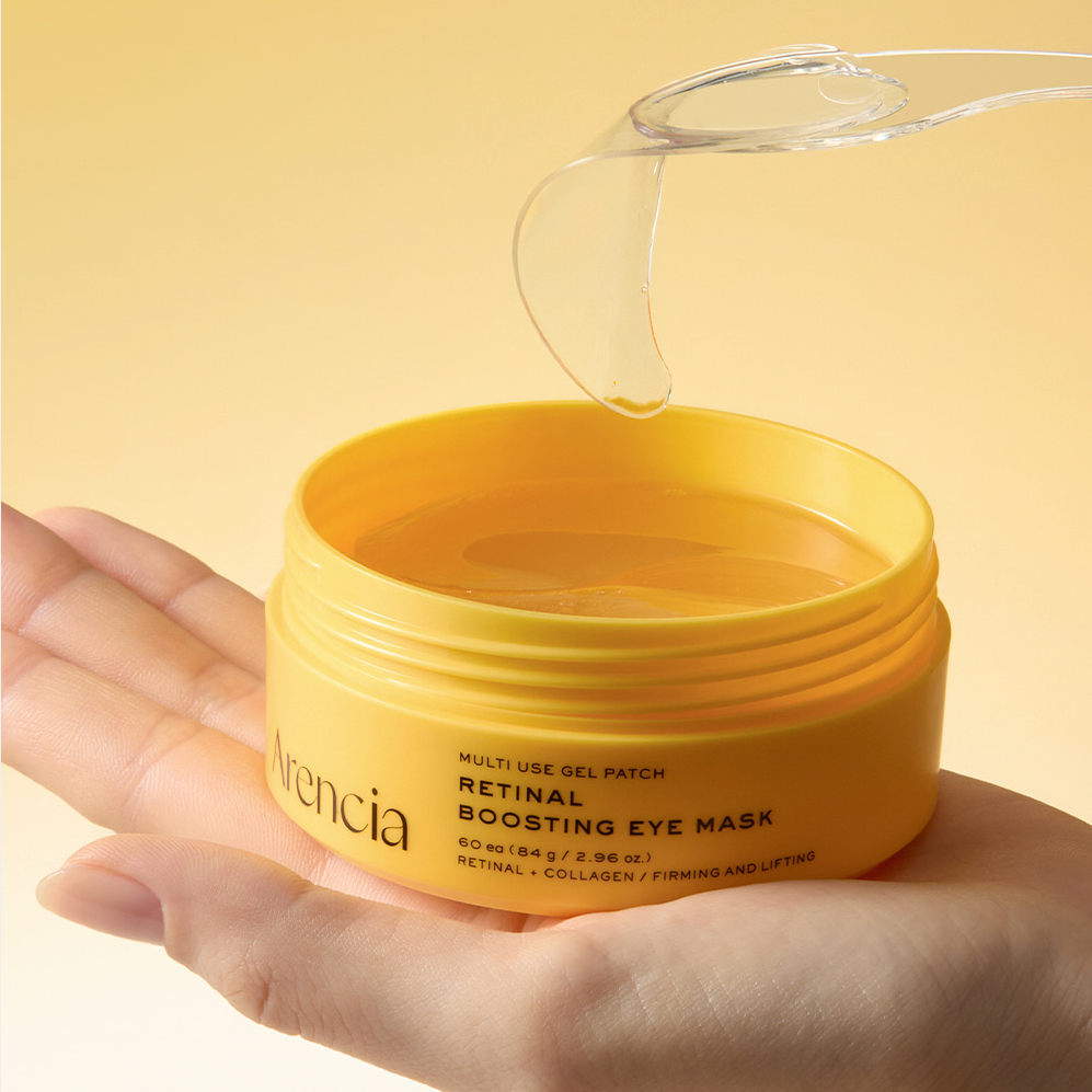 ARENCIA Retin-A Boosting Eye Mask 60ea : pot de masques pour le contour des yeux, main tenant le produit, fond beige.
