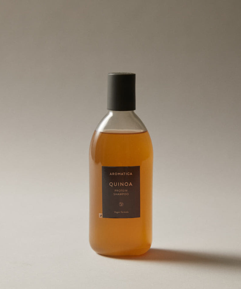 Décris l'image en français en mentionnant le produit, la marque et le contexte visuel: AROMATICA Quinoa Protein Shampoo 400ml, flacon sur fond clair.
